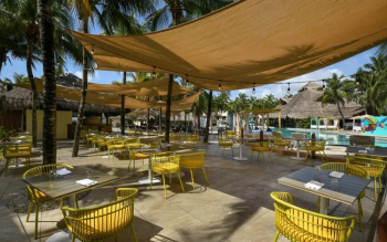 Outdoor seating area at La Cabaña Pizzería at El Dorado Royale Riviera Maya overlooking the
pool and tropical grounds.