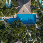 Aerial view of El Dorado Royale Riviera Maya showcasing tropical grounds, interconnected pools, palm-lined pathways, and accommodations at an adults-only all-inclusive resort in Mexico.