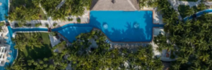 Aerial view of El Dorado Royale Riviera Maya showcasing tropical grounds, interconnected pools, palm-lined pathways, and accommodations at an adults-only all-inclusive resort in Mexico.